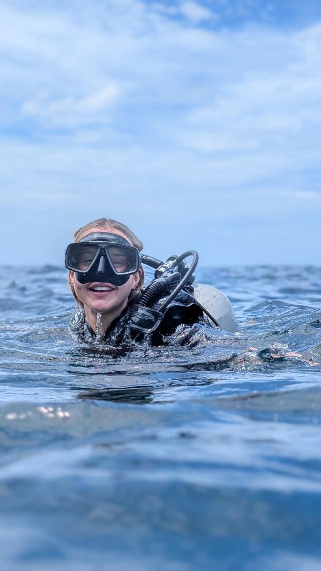 A certified PADI diver holding the Sri Lankan flag underwater with pride